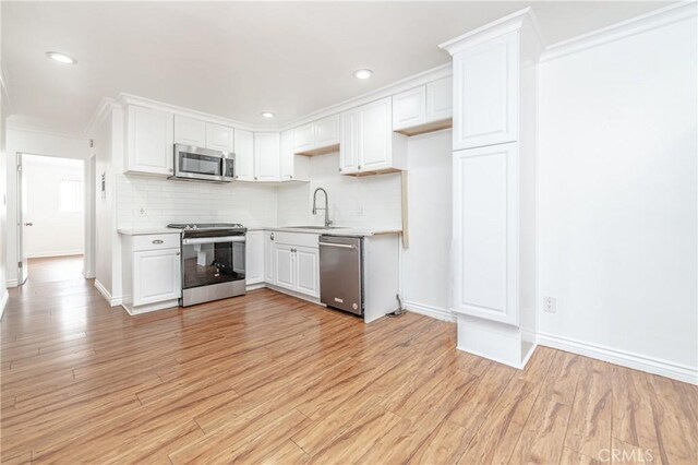 kitchen with white cabinetry, appliances with stainless steel finishes, sink, and light wood-type flooring