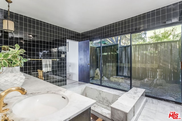 bathroom with sink and tile walls