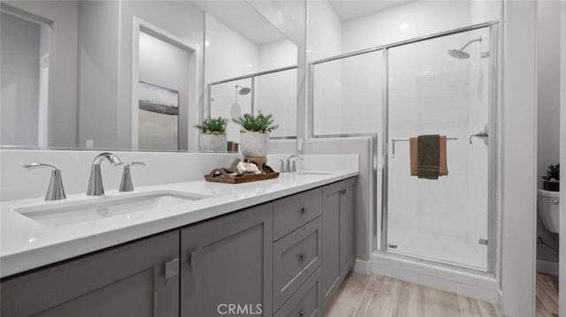 bathroom with hardwood / wood-style flooring, vanity, toilet, and walk in shower