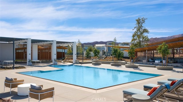 view of pool with a pergola, a patio, and a mountain view