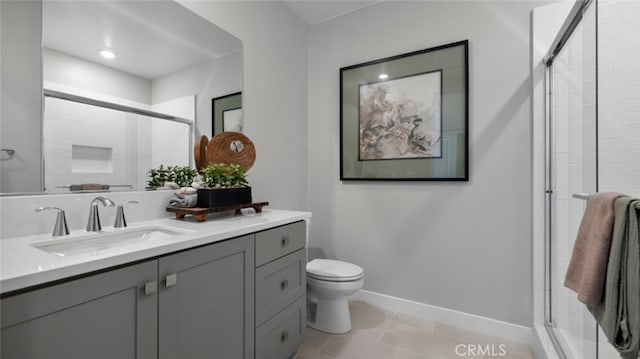 bathroom with tile patterned floors, vanity, toilet, and a shower with door