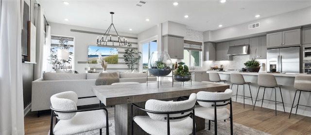 dining room with dark hardwood / wood-style floors, sink, and an inviting chandelier