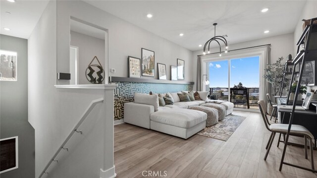 living room with an inviting chandelier and light hardwood / wood-style flooring