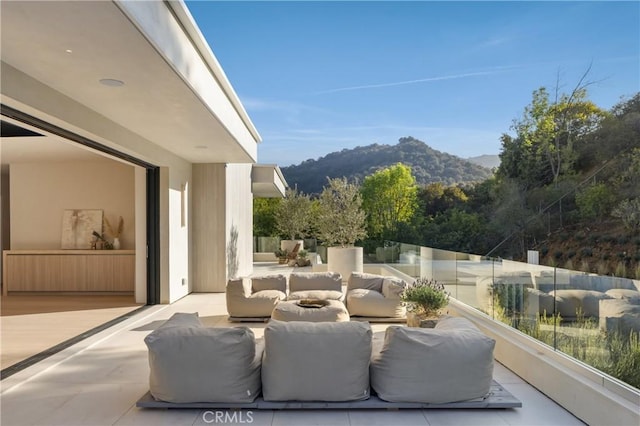 view of patio featuring a balcony, outdoor lounge area, and a mountain view