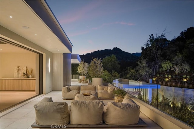 pool at dusk with a mountain view and an outdoor hangout area