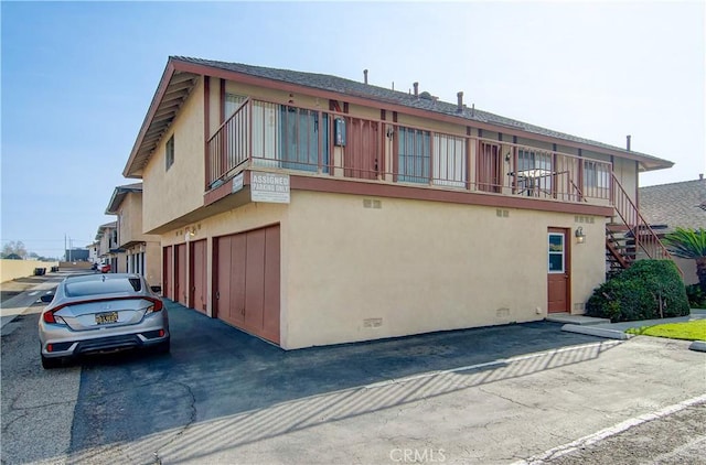 view of side of property with a garage and a balcony