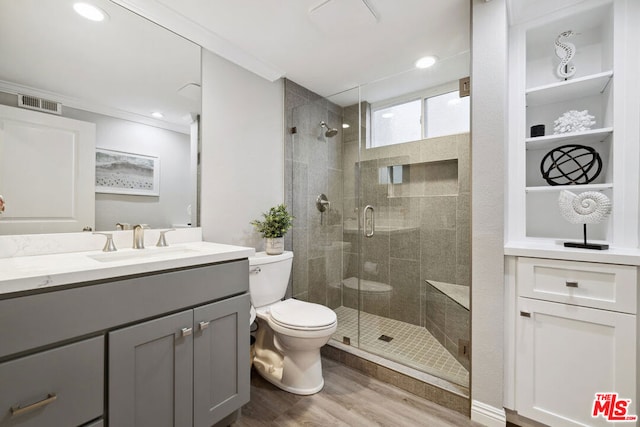 bathroom with vanity, ornamental molding, wood-type flooring, and a shower with door