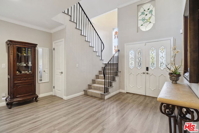 foyer entrance featuring ornamental molding and light wood-type flooring