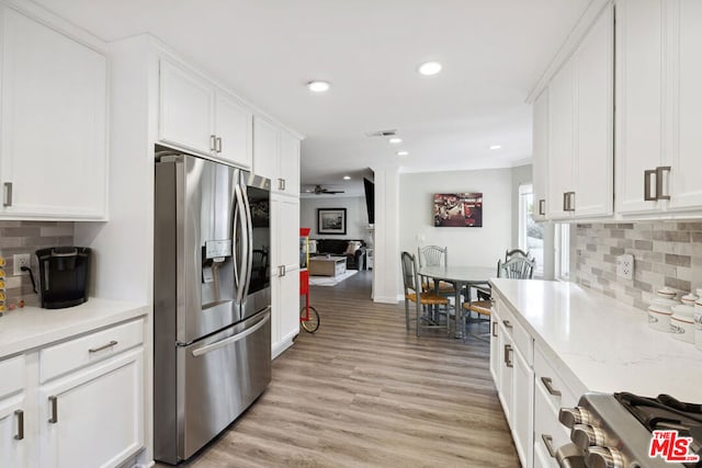 kitchen featuring light hardwood / wood-style flooring, ceiling fan, range, white cabinetry, and stainless steel refrigerator with ice dispenser