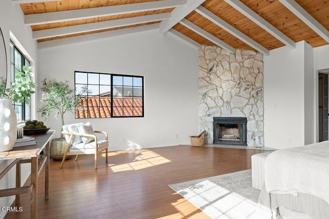 bedroom with beam ceiling, wood ceiling, high vaulted ceiling, hardwood / wood-style flooring, and a fireplace