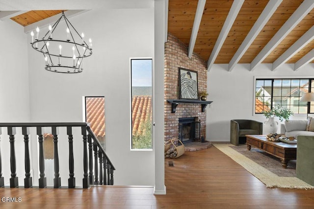 living room featuring beam ceiling, hardwood / wood-style floors, wooden ceiling, and a fireplace