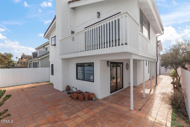 rear view of house featuring a balcony and a patio area