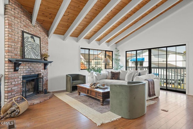 living room featuring high vaulted ceiling, a fireplace, hardwood / wood-style flooring, wooden ceiling, and beam ceiling