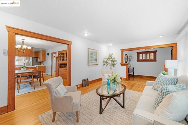 living room featuring an inviting chandelier and light hardwood / wood-style floors