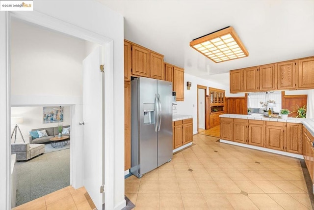 kitchen with tile countertops and stainless steel fridge