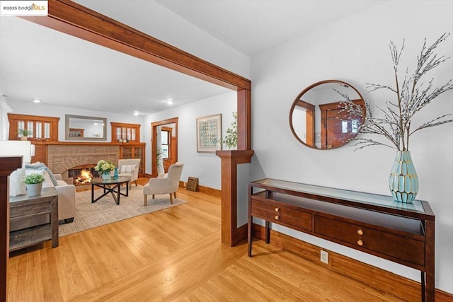 interior space with hardwood / wood-style flooring and a brick fireplace