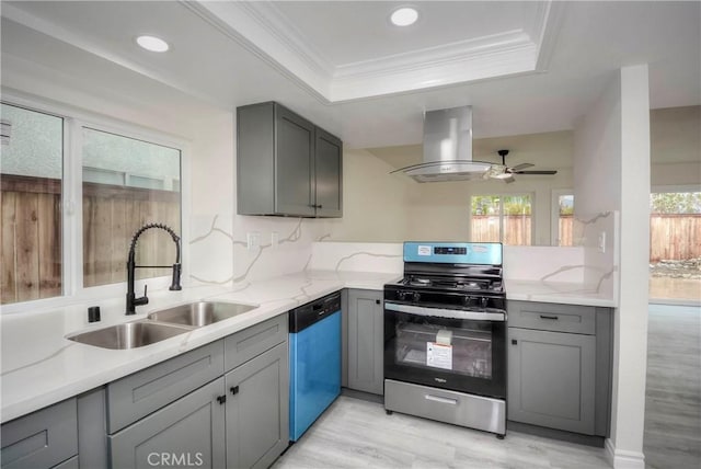 kitchen featuring sink, gray cabinets, a raised ceiling, island exhaust hood, and stainless steel appliances