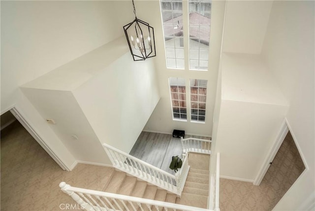 stairs featuring a notable chandelier