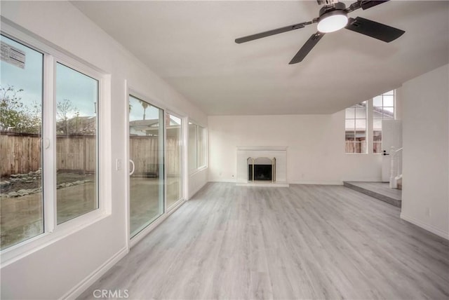 unfurnished living room featuring ceiling fan and light hardwood / wood-style flooring