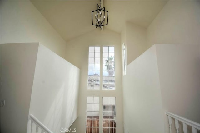 staircase featuring lofted ceiling and an inviting chandelier