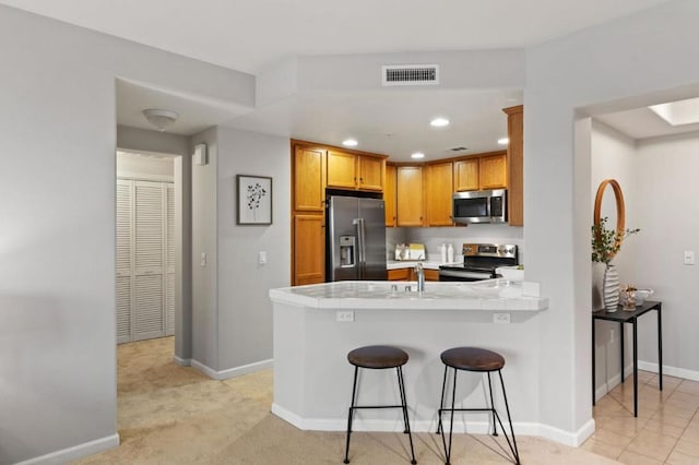 kitchen with appliances with stainless steel finishes, sink, light carpet, and kitchen peninsula