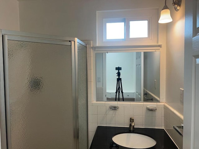 bathroom with tasteful backsplash, sink, and an enclosed shower