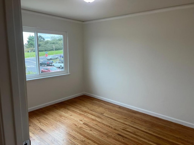 empty room with ornamental molding and light hardwood / wood-style floors