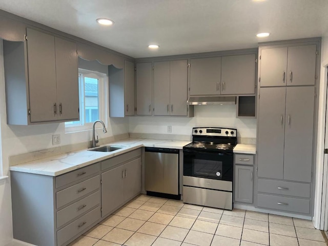 kitchen featuring gray cabinetry, sink, light tile patterned floors, and stainless steel appliances