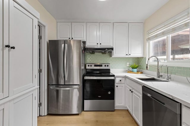 kitchen featuring light wood-type flooring, stainless steel appliances, sink, and white cabinets