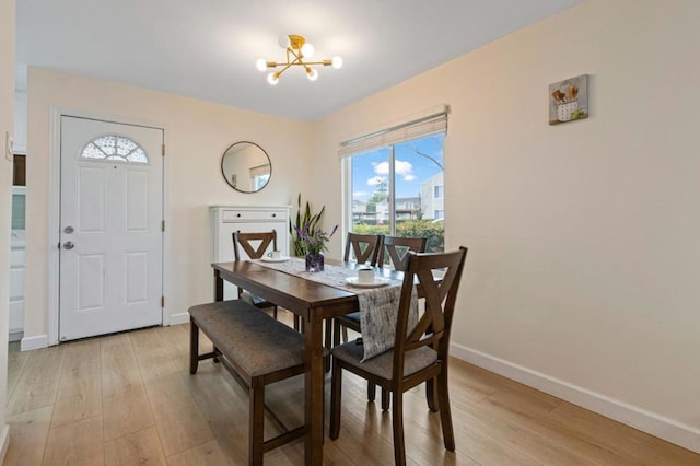 dining area featuring a notable chandelier and light wood-type flooring