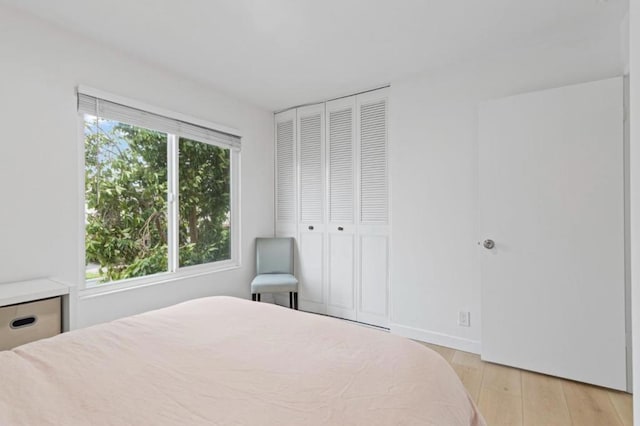 bedroom with light hardwood / wood-style flooring and a closet