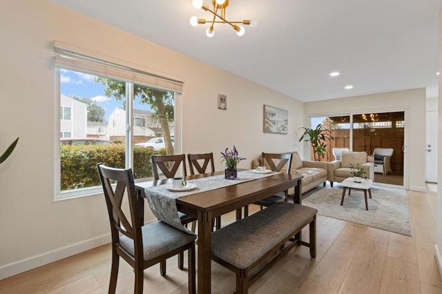 dining room with light hardwood / wood-style flooring and a chandelier