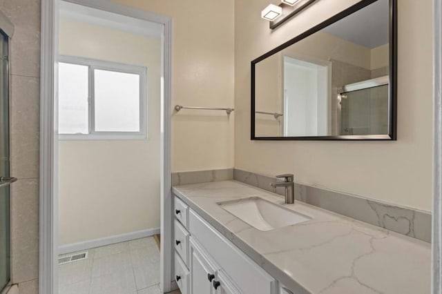 bathroom with tile patterned flooring, vanity, and a shower with shower door