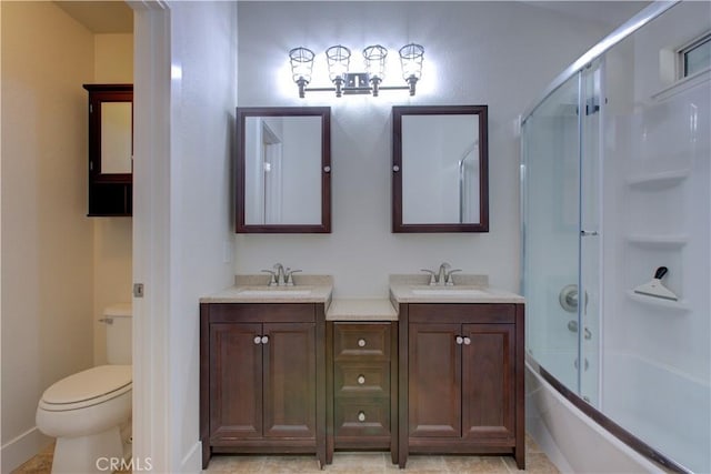 full bathroom featuring vanity, combined bath / shower with glass door, tile patterned floors, and toilet