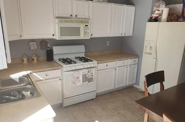 kitchen featuring sink, white cabinets, and white appliances