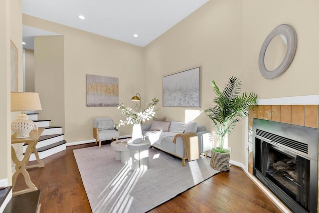 living room featuring dark hardwood / wood-style flooring and a tiled fireplace