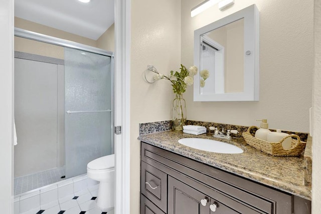 bathroom with tile patterned floors, vanity, toilet, and a shower with door