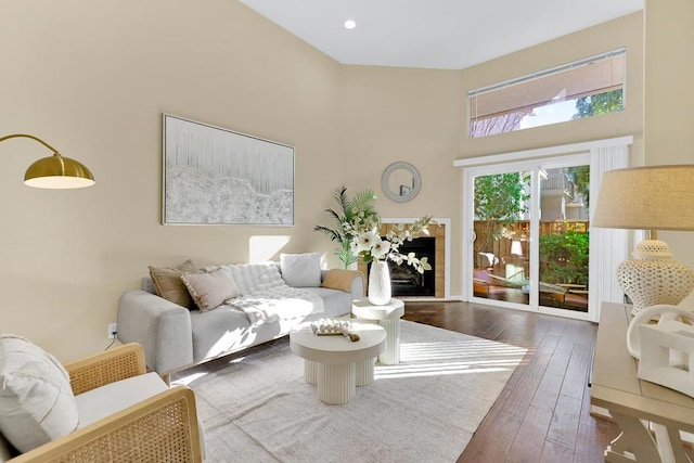 living room with dark wood-type flooring and a towering ceiling