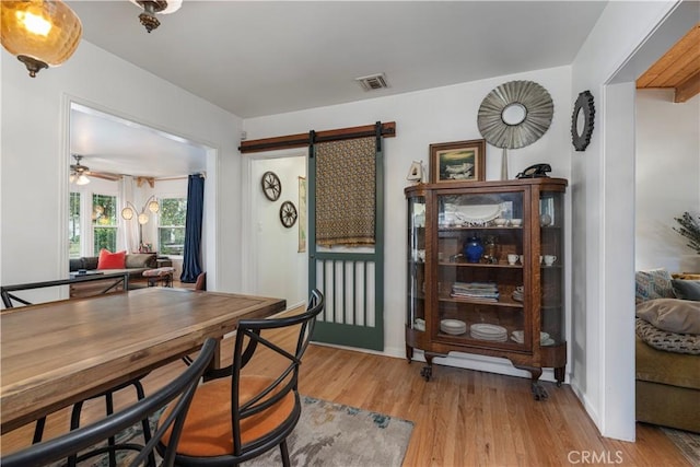 dining room with light hardwood / wood-style flooring and a barn door