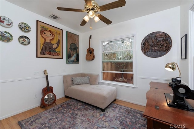 sitting room featuring wood-type flooring and ceiling fan