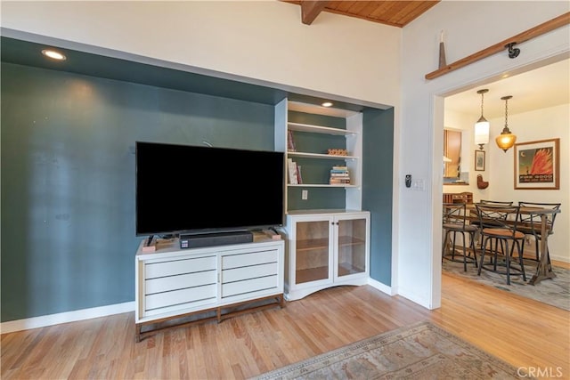 living room featuring beamed ceiling, wooden ceiling, and light hardwood / wood-style flooring