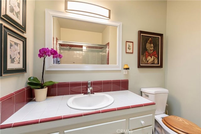 bathroom featuring vanity, toilet, and a shower