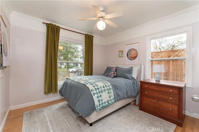 bedroom featuring light hardwood / wood-style flooring, ornamental molding, and ceiling fan