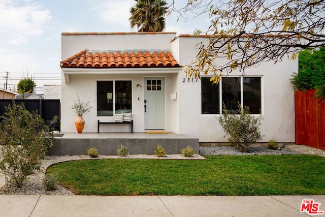 mediterranean / spanish house featuring a front lawn