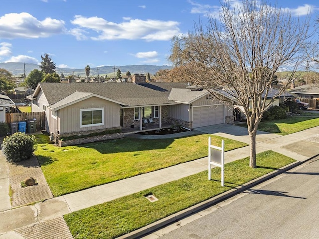 ranch-style home featuring a garage, a mountain view, and a front yard