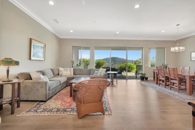 living area with light wood-style floors, recessed lighting, a mountain view, and an inviting chandelier