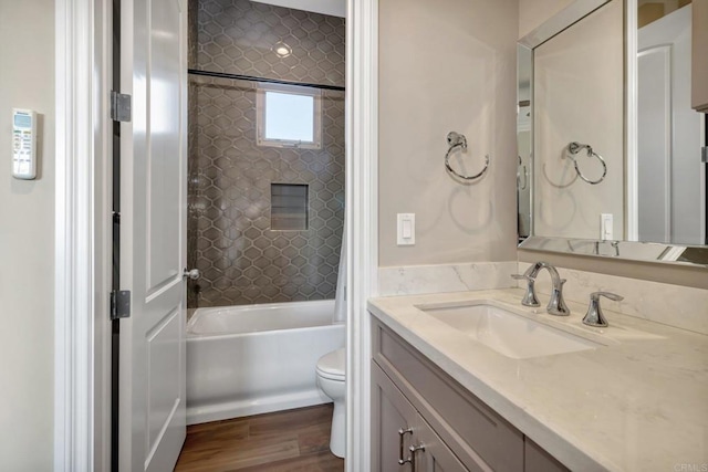 bathroom with washtub / shower combination, vanity, wood finished floors, and toilet