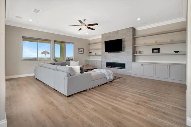 living area featuring light wood-style flooring, visible vents, and crown molding