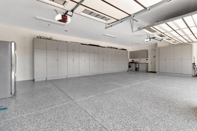 garage with freestanding refrigerator and a garage door opener