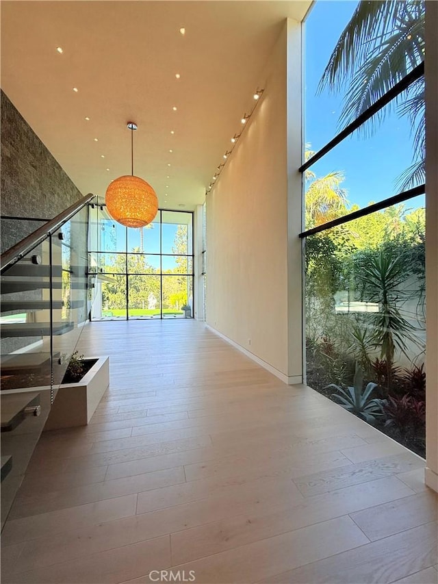 hall featuring a wall of windows and light hardwood / wood-style floors